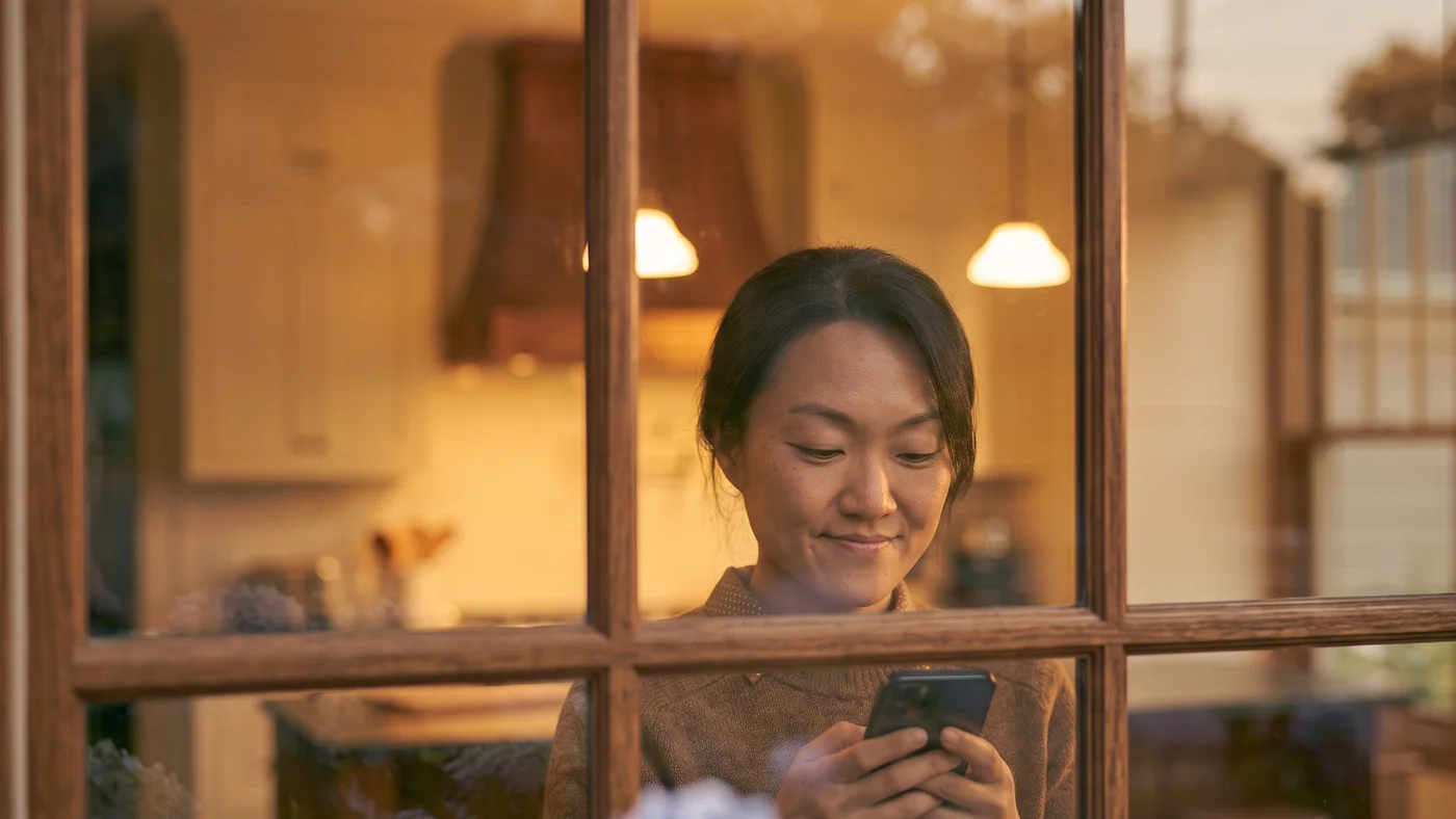 A homeowner checking her hauler's details on her phone from inside her home